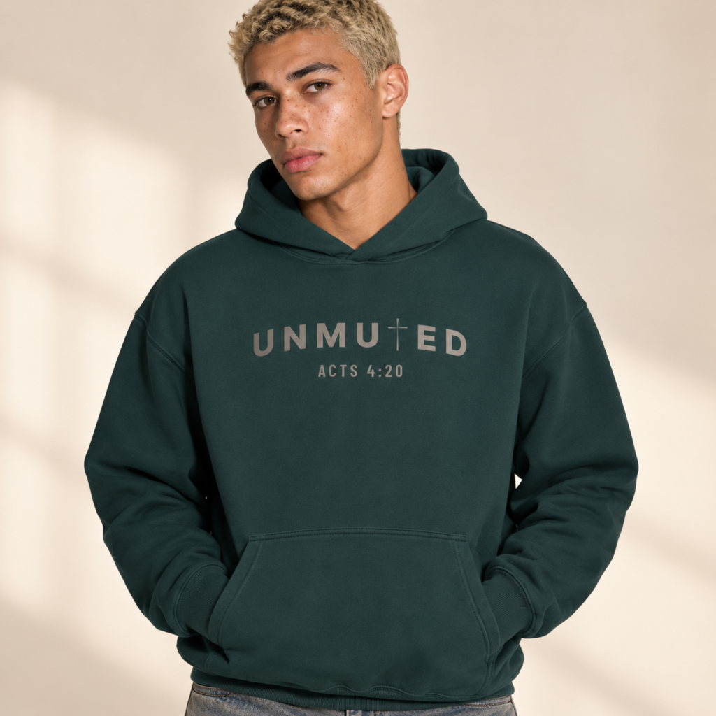 Male model wearing the UNMUTED Acts 4:20 pine green heavyweight hoodie