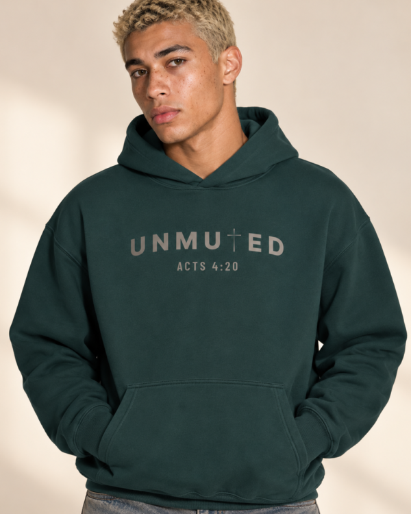 Male model wearing the UNMUTED Acts 4:20 pine green heavyweight hoodie