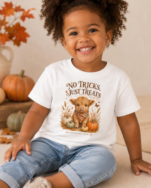 Smiling toddler wearing the No Tricks, Just Treats Tee with Highland cow and pumpkin design