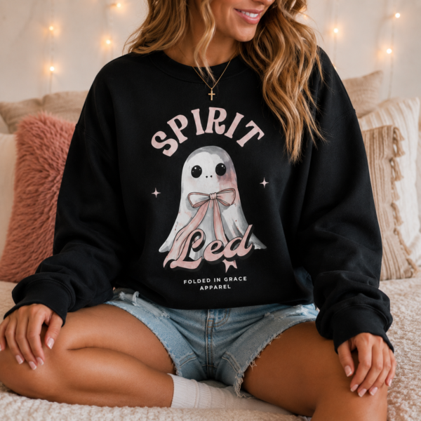 Woman wearing the Spirit Led Blushing Ghost Crewneck with watercolor ghost and pink bow design