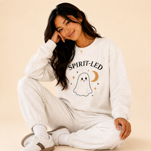 Woman wearing the Spirit-Led Ghost Crewneck with a playful ghost and crescent moon graphic.