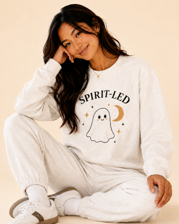 Woman wearing the Spirit-Led Ghost Crewneck with a playful ghost and crescent moon graphic.