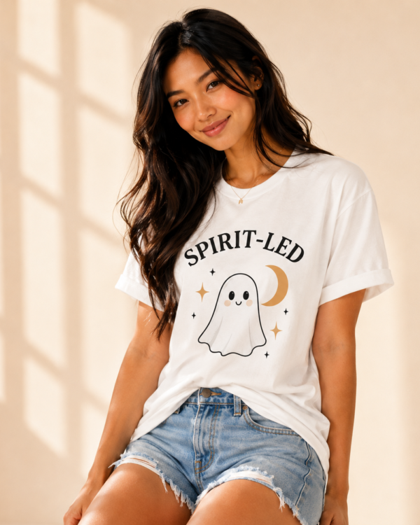 Woman wearing the Spirit-Led Ghost Tee with a playful ghost and crescent moon graphic.