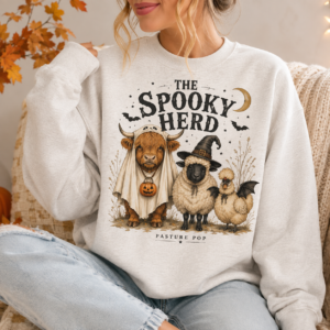 Woman wearing The Spooky Herd Crewneck with Highland cow, Valais Blacknose sheep, and Silkie Halloween design
